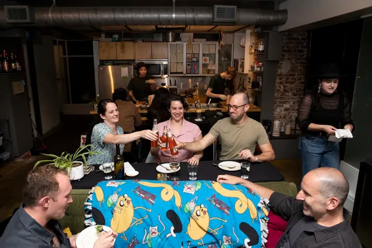 (left to right) Dylan Jackson, Rebecca Crosby, Gayle Burstein, Jordan Teitelbaum and Sharone Bilenkin toast during Spaghetti Western night at Couch Cafe at Liz Grothe’s apartment in Philadelphia, Pa. on Tuesday, May 30, 2023. Couch Cafe is a supper club that Grothe, a sous-chef at Fiorella, hosts at her apartment. 