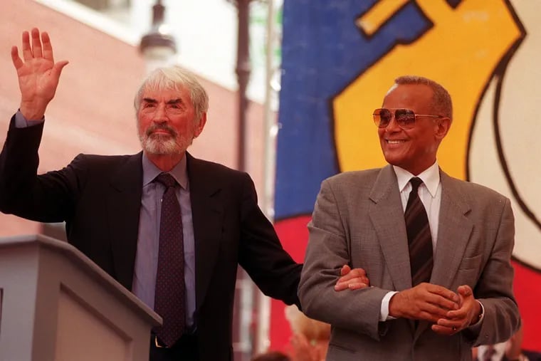 Gregory Peck waves to the crowd after recieving the Marian Anderson Award  as he is escorted off stage by Harry Belafonte in 1999.  Belafonte was the 1998 recipient. The award is given to an artist who use their talents for personal artistic expression coupled with a deep commitment to the betterment of society.