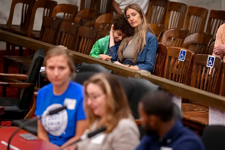 Christina Mattei, an interdisciplinary artist, composer, and multi-instrumentalist who taught music business, entrepreneurship, and technology at the University of the Arts sits with her 8 year-old son Atticus following her testimony at a Philadelphia City Council hearing Thursday.