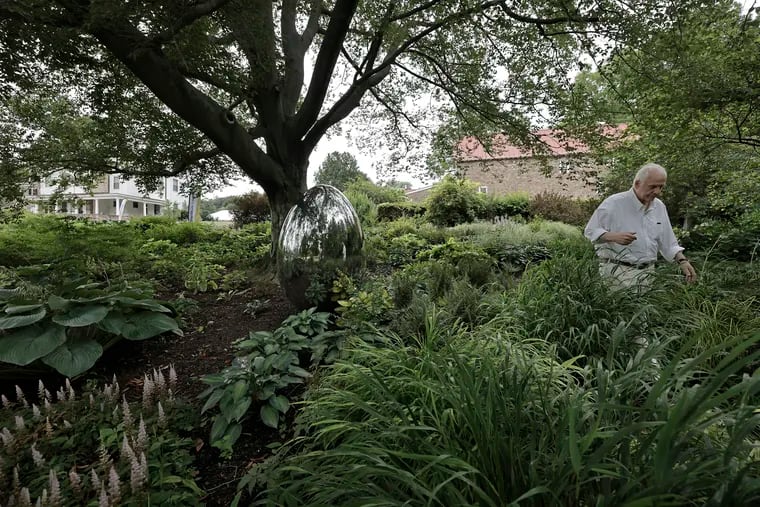 Burpee CEO George Ball in the Carolina Shade Garden that features a stainless steel egg by local artist Steve Tobin at Fordhook Farm in Doylestown, Pa. on Wednesday, July 24, 2024. Ball had the egg made to commemorate his mother, Vivian Caroline Ball.