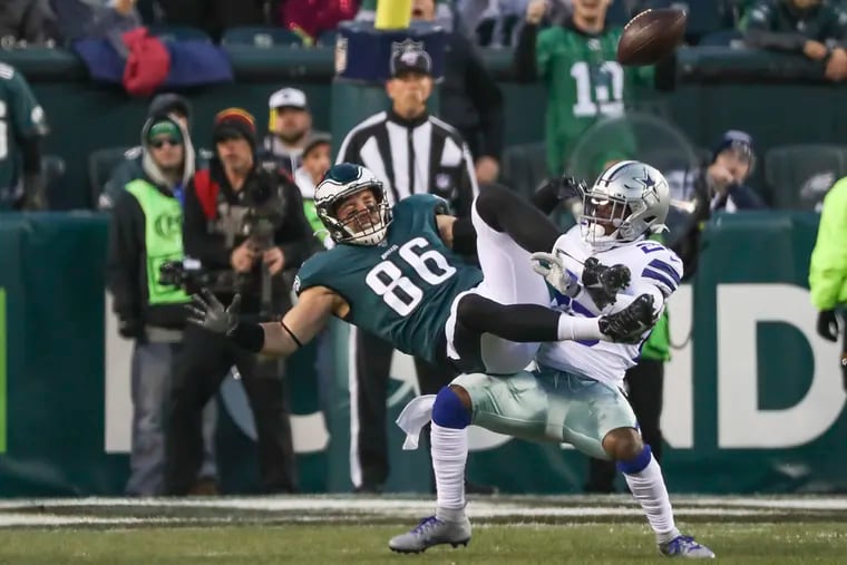 Eagles tight end Zach Ertz is brought down by Dallas Cowboys free safety Xavier Woods in the first half of a game at Lincoln Financial Field in South Philadelphia on Sunday, Dec. 22, 2019.
