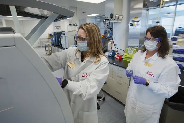 In this May 2020 photo provided by Eli Lilly, researchers prepare cells to produce possible COVID-19 antibodies for testing in a laboratory in Indianapolis.