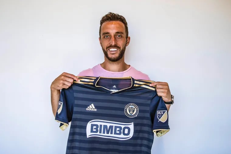 RJ Allen holds up a Philadelphia Union jersey after signing with the team.