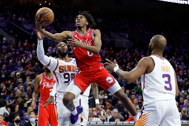 Tyrese Maxey of the Philadelphia 76ers shoots a lay up between Jae Crowder and Chris Paul of the Phoenix Suns  at Wells Fargo Center on February 08, 2022 in Philadelphia, Pennsylvania.