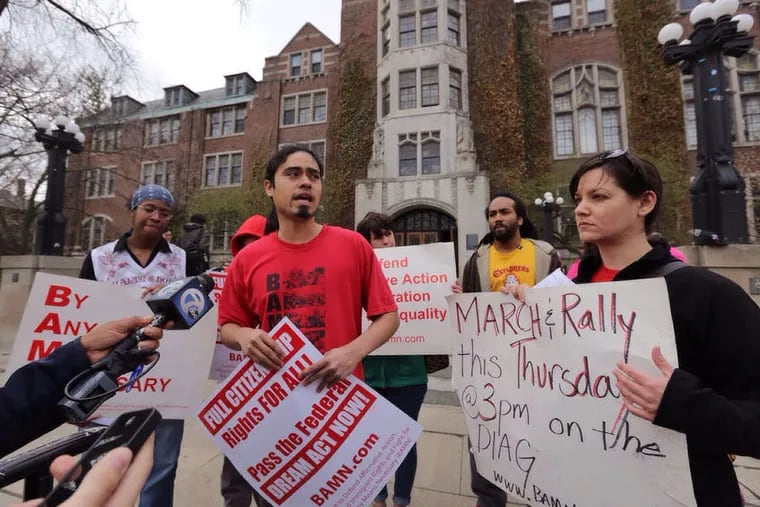Activist Jose Alvarenga (center), national organizer of the group BAMN, or By Any Means Necessary, which challenged the ban, reads a statement critical of the decision. He spoke on the campus of the University of Michigan.