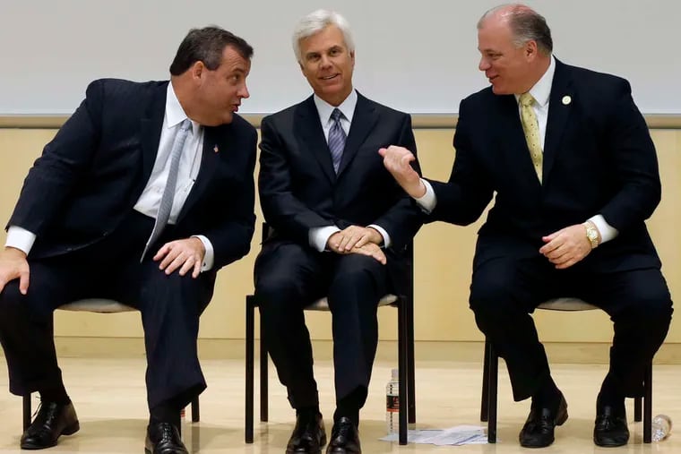In a file photo from 2014 in Camden, former Gov. Chris Christie (left) is joined by Democratic power broker George E. Norcross III (center) and Senate President Stephen Sweeney.