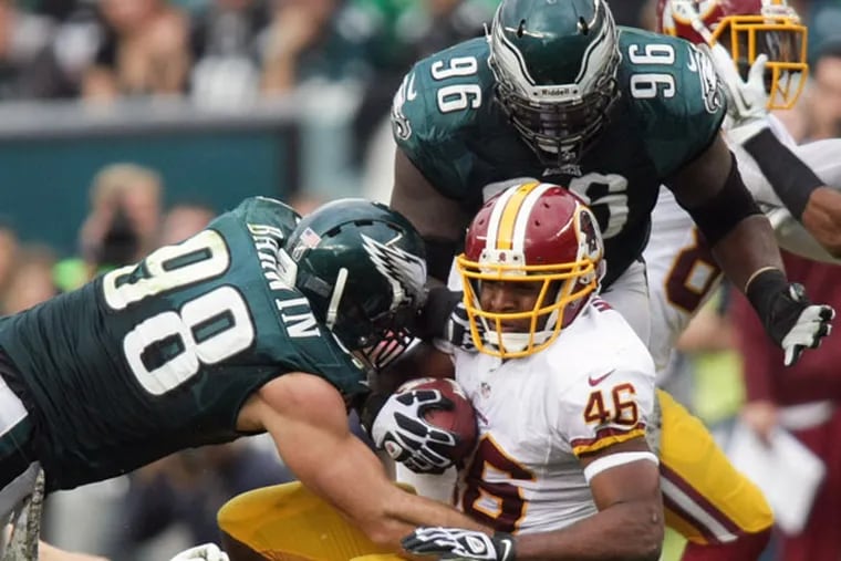 Eagles linebacker Connor Barwin, left, and defensive tackle Bennie Logan bring down Washington Redskins running back Alfred Morris during an NFL football game in Philadelphia, Sunday, Nov. 17, 2013. (AP Photo/The News-Journal, Andre L. Smith)