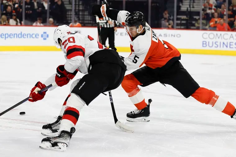 Flyers defenseman Egor Zamula defends New Jersey Devils center Michael McLeod on Thursday.