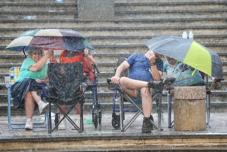 A fan walks in the stands as rain canceled the start of the