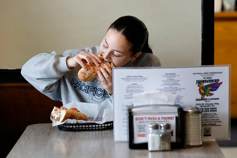 Jade Goffman eats the Thunderbird special with American cheese, ham, and sliced tomato at the Original Thunderbird in Broomall.