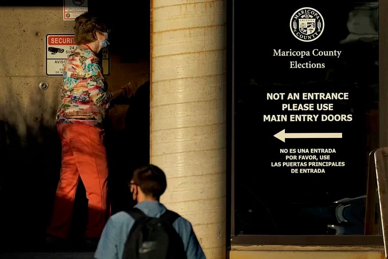 Election officials arrive for work at the Maricopa County Recorder's Office, Thursday, Nov. 5, 2020, in Phoenix. Hundreds of pro-Trump protesters gathered outside the ballot counting facility on Wednesday evening as outstanding votes were counted after Democratic challenger Joe Biden was reported to have flipped the Republican stronghold of Arizona. (AP Photo/Matt York)