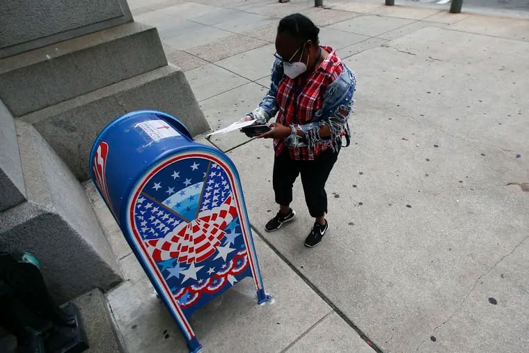 In this file photo, a voter prepares to drop off a ballot at a drop box outside Philadelphia City Hall on May 28, 2020.