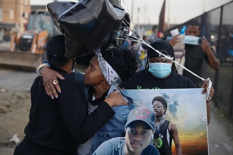 Nydisha Williams (left) hugs Adrienne Moore (center) and Alicia Moore before a vigil for Williams' slain 15-year-old son, Antonio Walker Jr. at Bartram Field in Southwest Philadelphia on March 11, 2021. Walker Jr. was shot and killed, apparently at random, on the 5200 block of Pentridge Street.