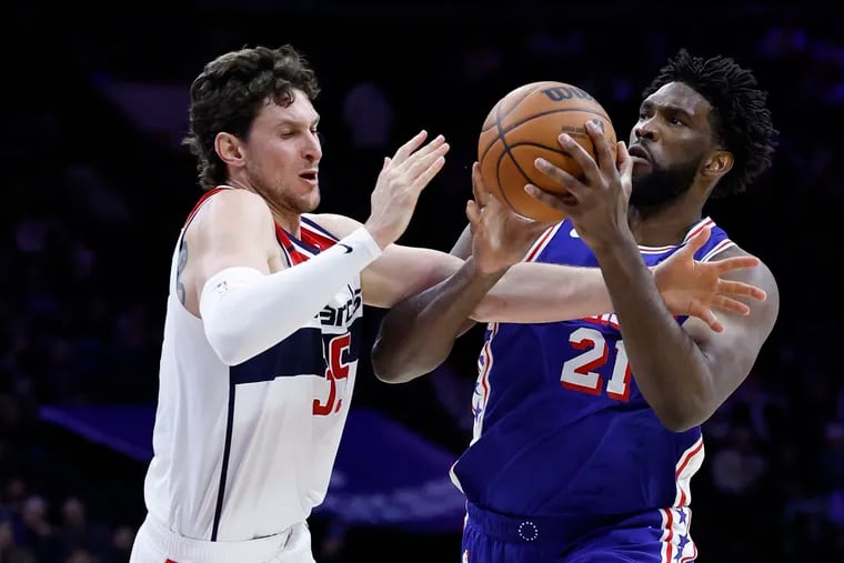 Sixers center Joel Embiid gets fouled by Wizards center Mike Muscala in the third quarter.