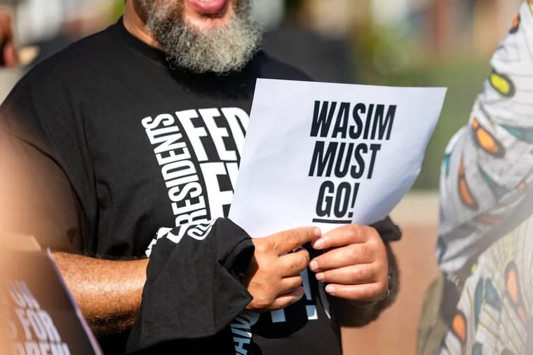 A sign that reads “Wasim must go!” is shown during a protest before a Camden School Advisory Board Meeting at Camden High School in Camden, New Jersey on Tuesday, Aug. 27, 2024. Community activists called for Muhammad to step down from his role as president.