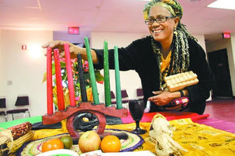 Dolores Streater-Logan adjusts candles that represent the seven Kwanzaa principles.