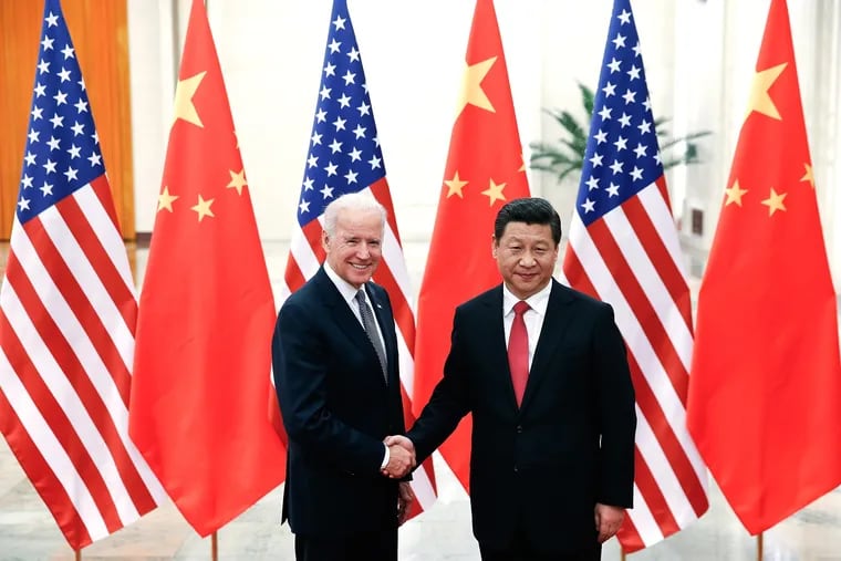 Chinese President Xi Jinping, right, shakes hands with then U.S. Vice President Joe Biden inside the Great Hall of the People in 2013, in Beijing.