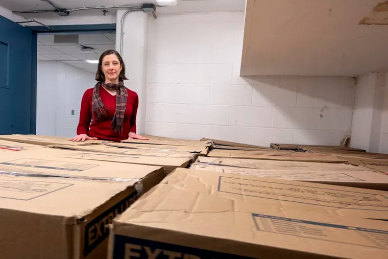 Kimberlee Sue Moran, a professor and director of forensics at Rutgers University-Camden, in February with boxes containing the carefully stored remains of nearly 500 people who were buried in the old First Baptist Church cemetery on Arch Street in Philadelphia.