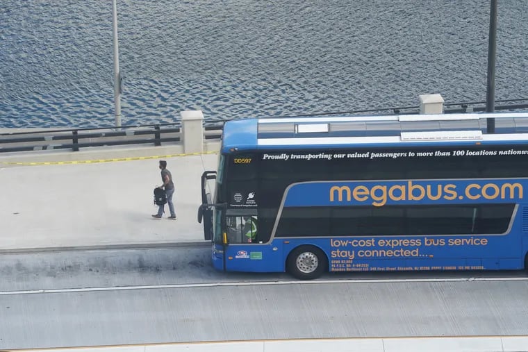 A passenger exits a Megabus near 30th Street Station.