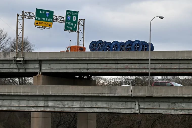 Traffic moves on the southbound Roosevelt Expressway bridge (top) over the Schuylkill. PennDot officials shut down the ramp (right) from Roosevelt Expressway to I-76 West Tuesday after discovering structural damage following a crash.