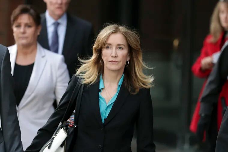 FILE - This April 3, 2019 file photo shows actress Felicity Huffman departing federal court in Boston after facing charges in a nationwide college admissions bribery scandal. Federal prosecutors are asking a judge to sentence “Desperate Housewives” star Felicity Huffman to a month in jail for her role in the sweeping college admissions bribery scandal.