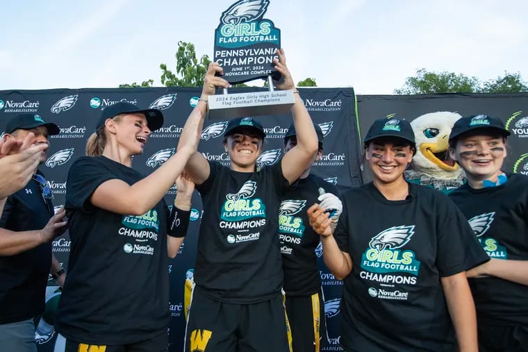 Ava Renninger of Archbishop Wood holds up the championship trophy in the Eagles' Pennsylvania flag football championship on June 1.