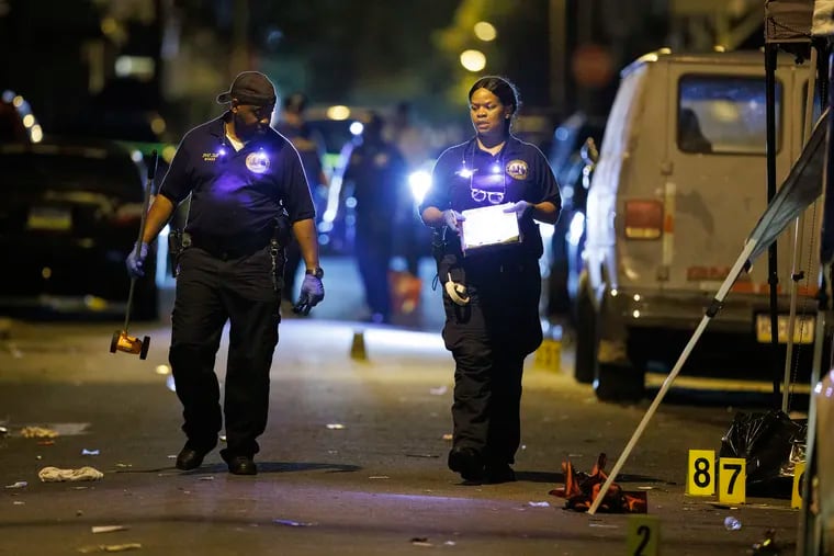 Philadelphia Crime Scene Unit officers and detectives investigate that left multiple people dead and injured in the Carroll Park section of Philadelphia.