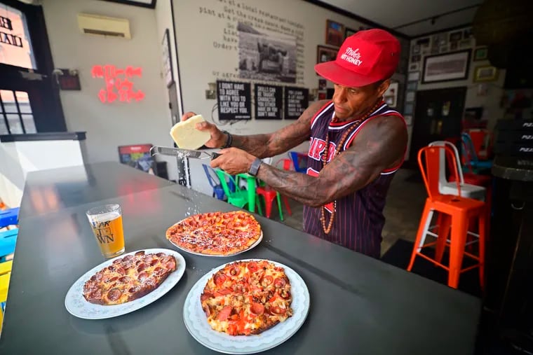 At Bar Jawn, owner David Lee adds cheese to pizzas he had baked at Pizza Jawn a block away.