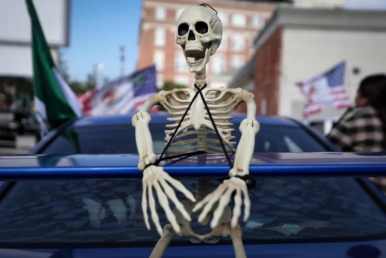 A toy skeleton rests on the back of a car for the decorated car parade in Philadelphia.