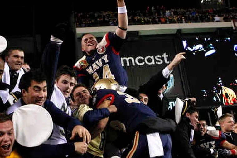 Navy players join fans in celebrating the Midshipmen's eighth victory in a row against Army in the 110-game football rivalry. For the third year in a row Navy prevented Army from scoring a touchdown.