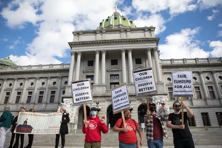 Supports hold signs during a school funding rally on the steps of the Capitol Building in Harrisburg on Friday, Nov. 12, 2021, the first day of the trial suing the state over how it funds schools. Kalim A. Bhatti / For The Inquirer