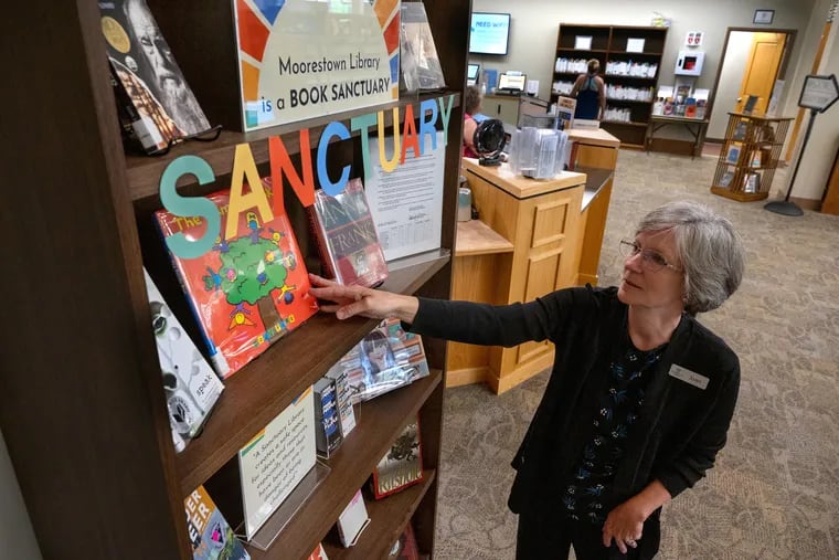 Joan Serpico, director of the Moorestown Library, at the sanctuary shelf. The library has become a book sanctuary, the first in South Jersey under a growing movement in the state to protect book freedom.