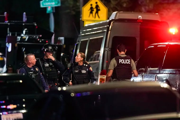 Law enforcement personnel gather at the scene where two police officers were shot Tuesday in Newark, N.J.