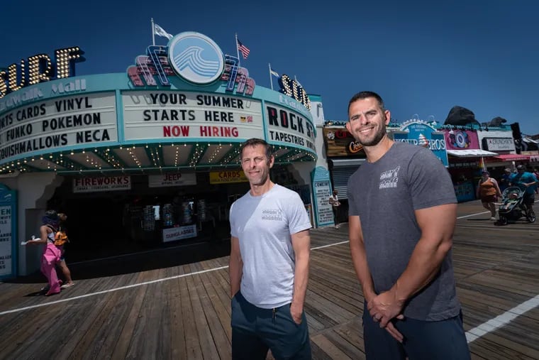 At Ocean City's Surf Mall, co-owner Chris Kazmarck (right) has a card fee at his businesses while his brother and co-owner, Wes, does not.