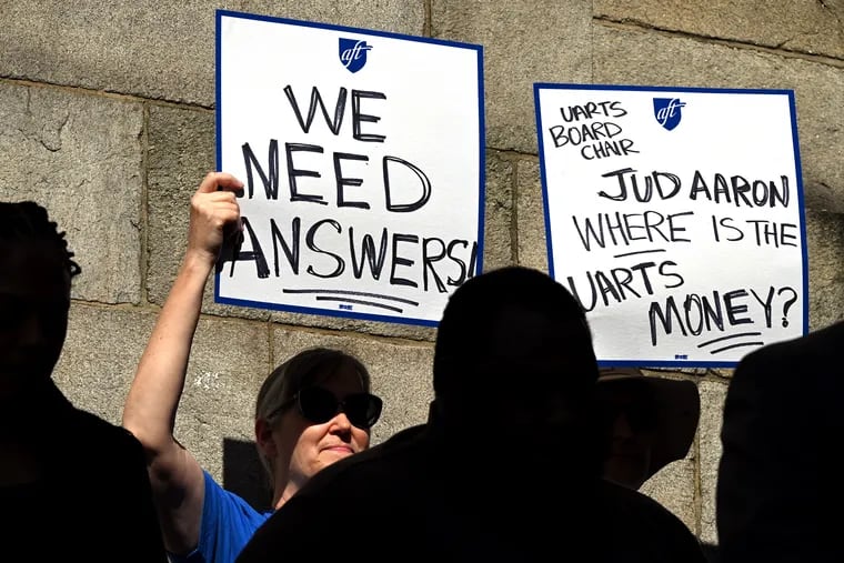 Union members of the United Academics of Philadelphia hold signs, including one naming Judson Aaron, chairperson of the university’s board of trustees, during a news conference outside Hamilton Hall on the former University of the Arts campus on Thursday.