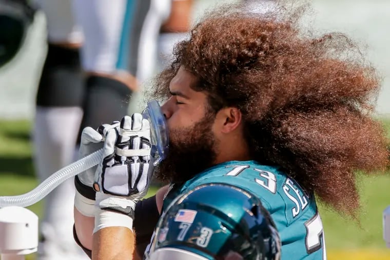 Isaac Seumalo, here getting oxygen on the Eagles sideline Sunday, went down with a knee injury.