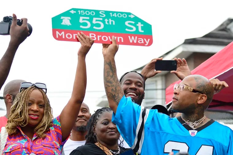 Councilmember Jamie Gauthier and Rapper Mont Brown hold up the street sign honoring the Southwest Philadelphia native during street renaming ceremony at the 13th Annual Stop the Violence Kickback Block Party at 55th Street and Chester Avenue, in Southwest Philadelphia on August 17, 2024.