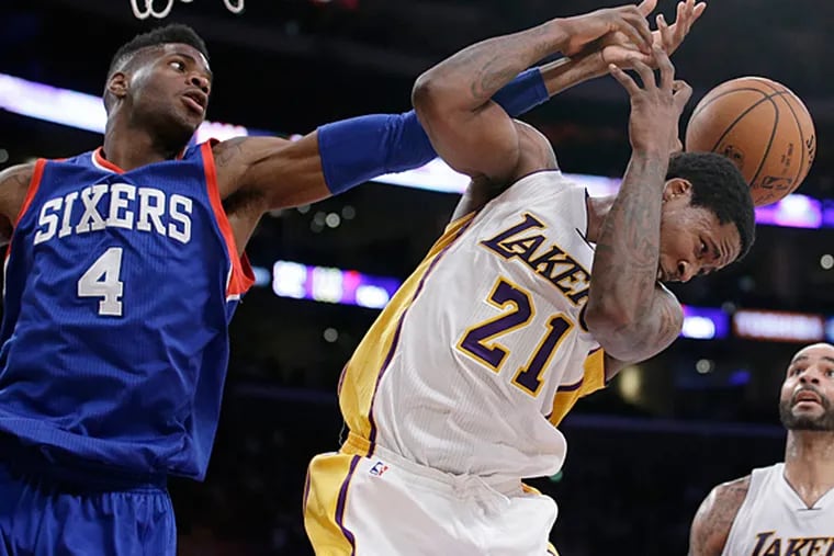 Los Angeles Lakers' Ed Davis, right, and Philadelphia 76ers' Nerlens Noel fight for a rebound during the second half of an NBA basketball game, Sunday, March 22, 2015, in Los Angeles. The Lakers 101-87. (Jae C. Hong/AP)