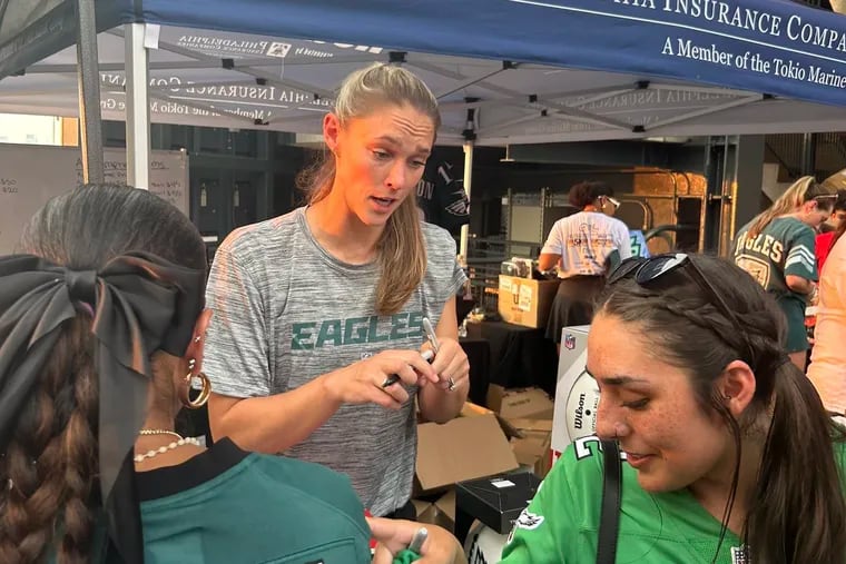 Kylie Kelce signs autographs and meets with fans on behalf of the Eagles Autism Foundation at the team's open practice Thursday night.