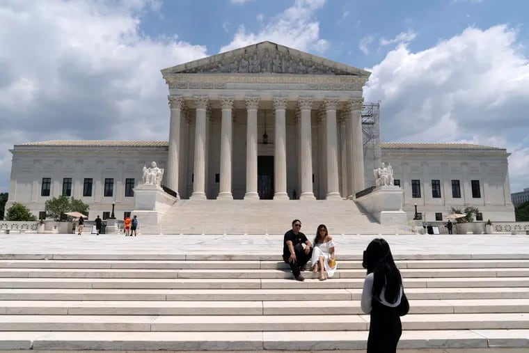 Visitors pose for photographs outside the U.S. Supreme Court on Tuesday, June 18, 2024.