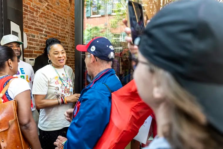 Dawn Staley chats with David Beck, 68, of Glenside, as she arrives at Mitchell & Ness. Staley is a North Philly native who recently won her third national title as the South Carolina women's basketball coach.