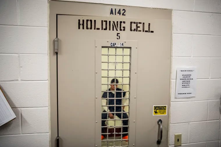 A detainee sits in a holding cell.