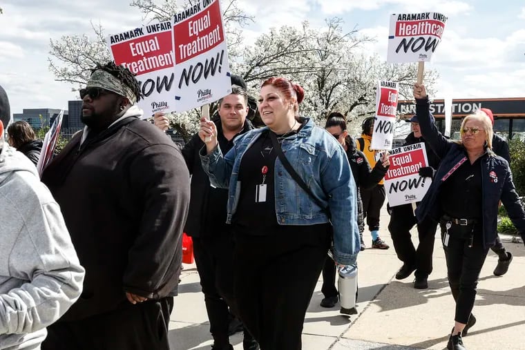 Sam Spector (center) walks the line with concessions workers from the Wells Fargo Center, Citizens Bank Park, and Lincoln Financial Field. They are employed by Aramark and represented by Unite Here Local 274, and they rallied on March 18 as they seek a single contract with better wages and health-care coverage.