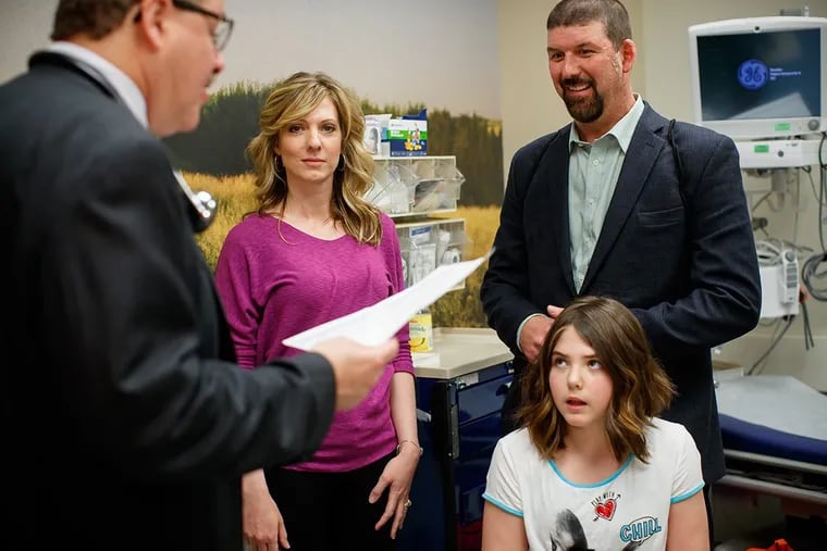 Dr. Stephan Grupp gives Emily Whitehead, and her parents, Tom and Kari results confirming her cancer has remained in remission for more than five years during a patient visit to CHOP in May, 2017.