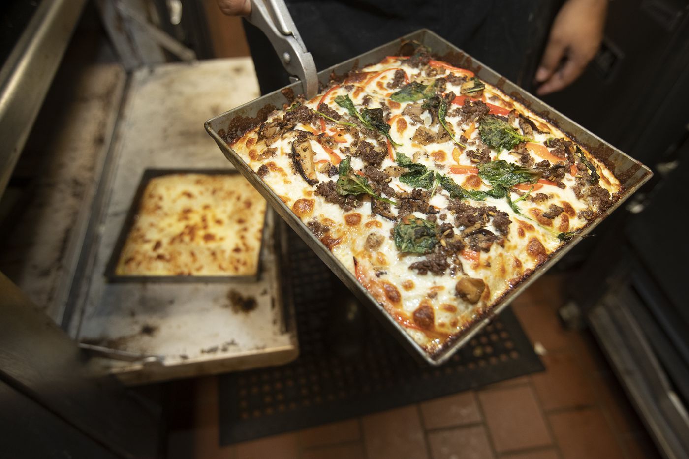 The square Detroit-style pizzas are taken out of the oven at Down North, an eatery with a social mission to give employment opportunities to formerly incarcerated people.