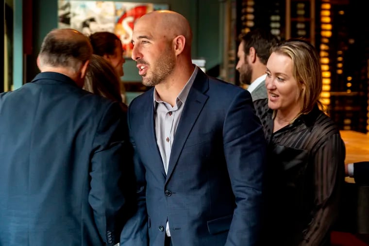 Former Eagles Chris Maragos is with his wife Serah Maragos (right) and his law team at a Center City restaurant Monday, Feb. 13, 2023 following a jury’s finding against his doctors, ordering them to pay the ex-NFL All-Pro player $43.5 million.