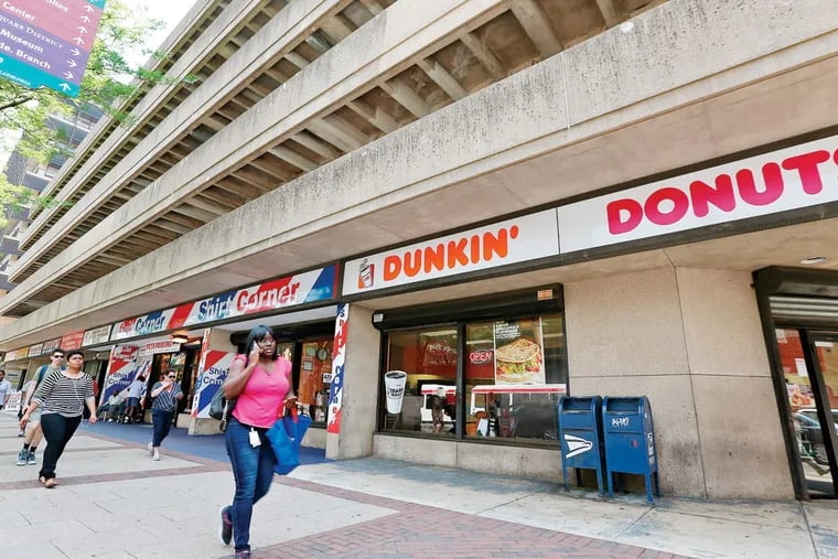 Pedestrians walk by the parking garage at 7th and Market streets in Philadelphia, Pa. on May 28, 2015. (DAVID MAIALETTI / Staff Photographer)