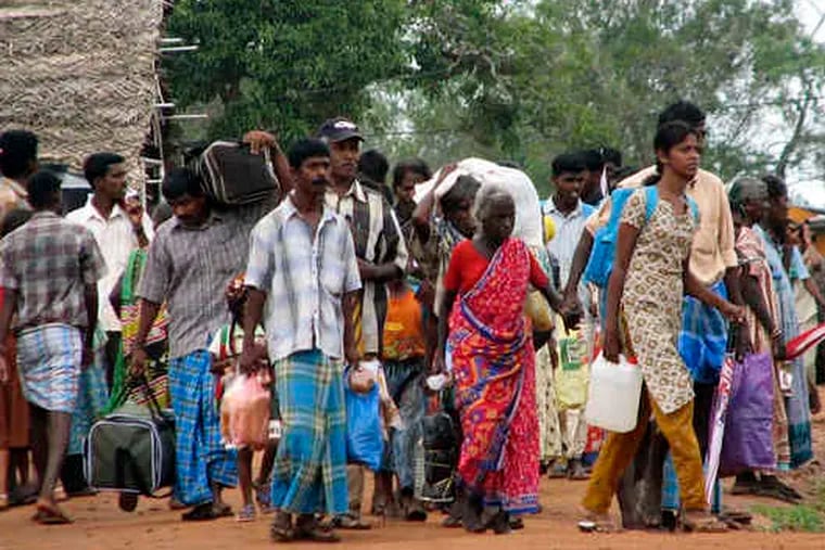 Ethnic Tamils leave camps for displaced persons in Manik Farm, Sri Lanka. After the war ended, the government herded civilians into the camps, which are to be closed by the end of January.