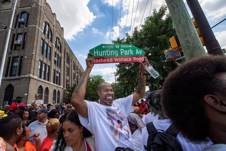 Former NBA player Rasheed Wallace raises his street sign last month after the block of 18th and Hunting Park Ave was officially named Rasheed Wallace Road.