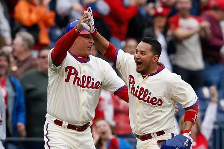 Ryne Sandberg, left, high-fives Freddy Galvis, right, after he hit a walk-off home run as the Phillies win 3-2 over the Reds at Citizens Bank Park. ( DAVID MAIALETTI / Staff Photographer )